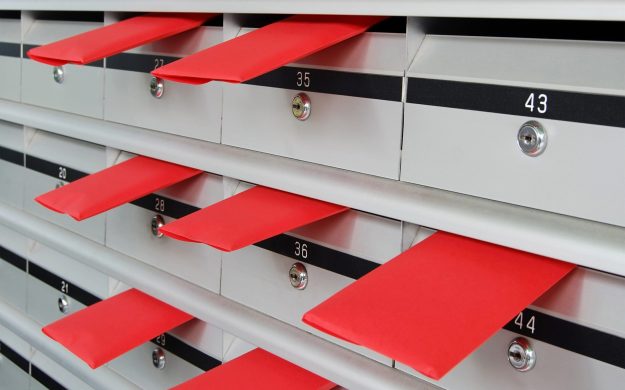 Letterboxes in rows with letters in red envelopes